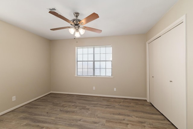 706 Matilda St, Brenham, TX 77833 - unfurnished bedroom with wood finished floors, a closet, and a ceiling fan