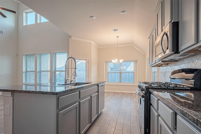1111 Teamriddle Way, Richmond, TX 77406 - kitchen featuring stainless steel appliances, gray cabinetry, a chandelier, backsplash, and vaulted ceiling