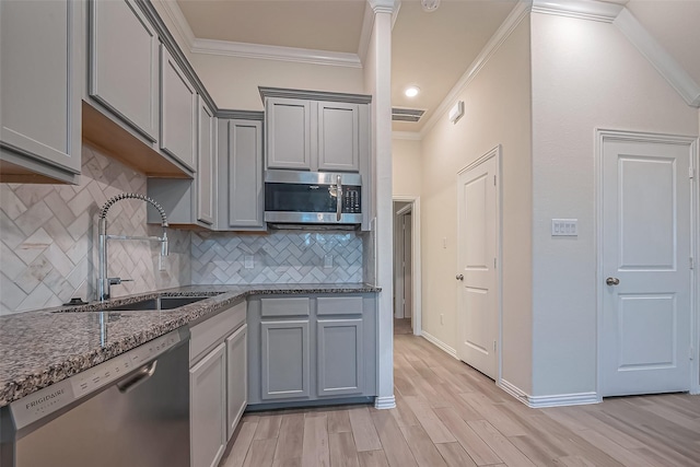 1111 Teamriddle Way, Richmond, TX 77406 - kitchen featuring stainless steel appliances, ornamental molding, gray cabinetry, dark stone countertops, and tasteful backsplash