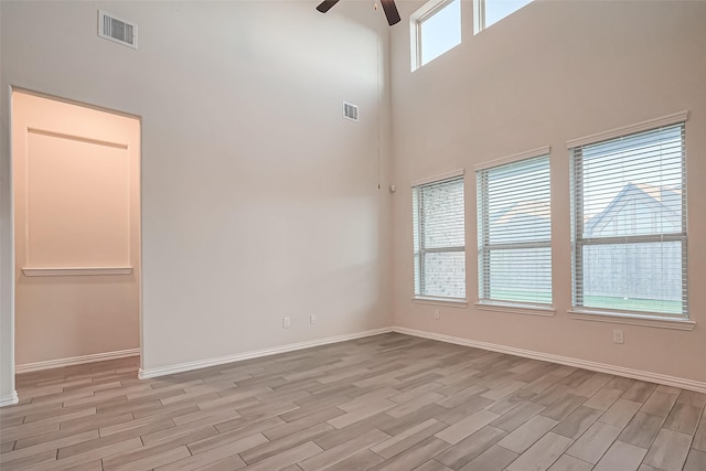 1111 Teamriddle Way, Richmond, TX 77406 - empty room with a ceiling fan, light wood finished floors, and a towering ceiling