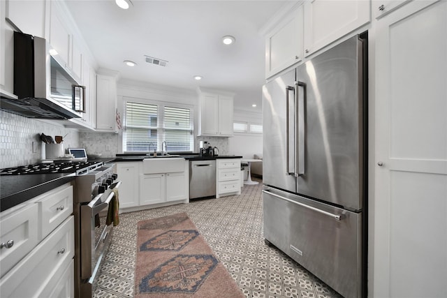 604 E 10th 1/2 St, Houston, TX 77008 - kitchen with high end appliances, dark countertops, white cabinetry, backsplash, and recessed lighting