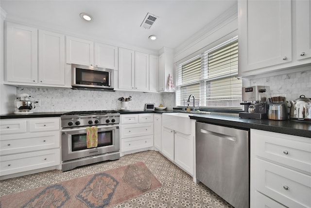 604 E 10th 1/2 St, Houston, TX 77008 - kitchen with stainless steel appliances, dark countertops, white cabinetry, decorative backsplash, and recessed lighting
