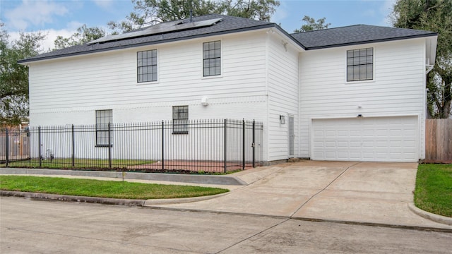 4400 Edith St, Bellaire, TX 77401 - view of front of house featuring a garage, concrete driveway, solar panels, and roof with shingles