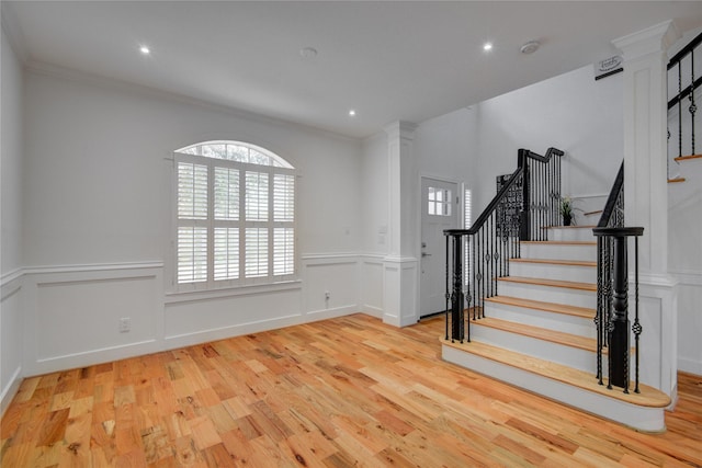 4400 Edith St, Bellaire, TX 77401 - foyer featuring ornate columns, stairs, wood finished floors, healthy amount of natural light, and a wainscoted wall
