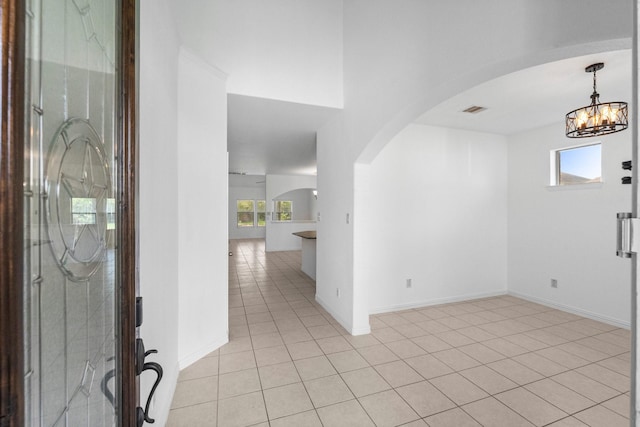22303 Mosshall Ct, Tomball, TX 77375 - foyer with arched walkways, healthy amount of natural light, a chandelier, and light tile patterned flooring