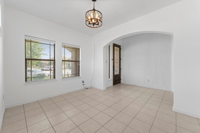 22303 Mosshall Ct, Tomball, TX 77375 - empty room with arched walkways, a chandelier, and light tile patterned floors