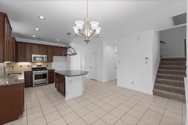 22303 Mosshall Ct, Tomball, TX 77375 - kitchen featuring stainless steel appliances, recessed lighting, a chandelier, dark stone countertops, and a kitchen island