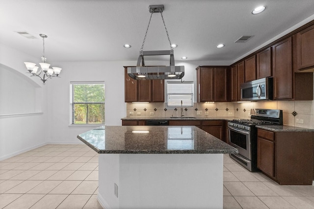 22303 Mosshall Ct, Tomball, TX 77375 - kitchen featuring stainless steel appliances, backsplash, dark stone countertops, light tile patterned floors, and recessed lighting