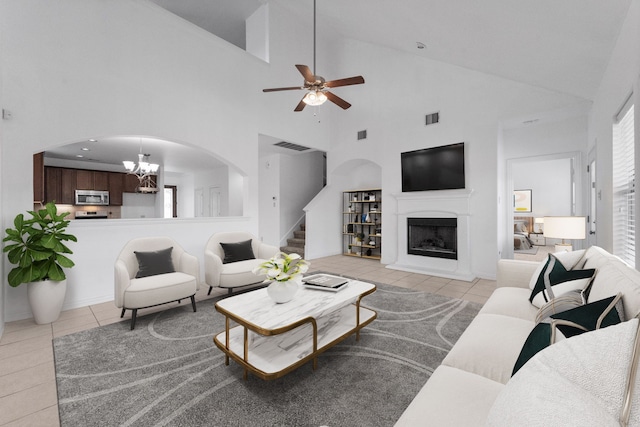 22303 Mosshall Ct, Tomball, TX 77375 - living room with light tile patterned floors, high vaulted ceiling, a fireplace with raised hearth, stairway, and a ceiling fan