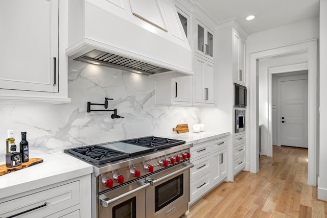 4902 Oak Forest Dr, Houston, TX 77018 - kitchen with range with two ovens, custom exhaust hood, white cabinetry, tasteful backsplash, and glass insert cabinets