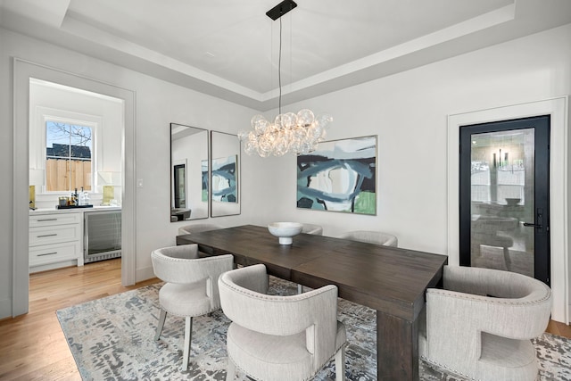 4902 Oak Forest Dr, Houston, TX 77018 - dining room with a raised ceiling, beverage cooler, light wood-style floors, and a chandelier