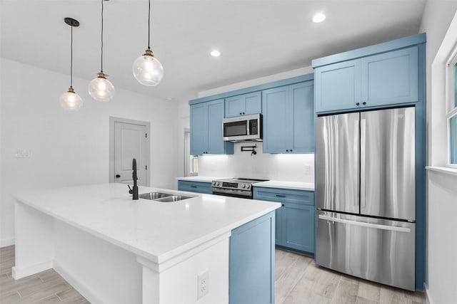112 Whiteface Dr, Mabank, TX 75156 - kitchen featuring stainless steel appliances, blue cabinetry, light wood-style floors, an island with sink, and recessed lighting