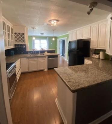 160 E Darby St, Bridge City, TX 77611 - kitchen featuring a peninsula, stainless steel appliances, white cabinetry, dark wood finished floors, and glass insert cabinets