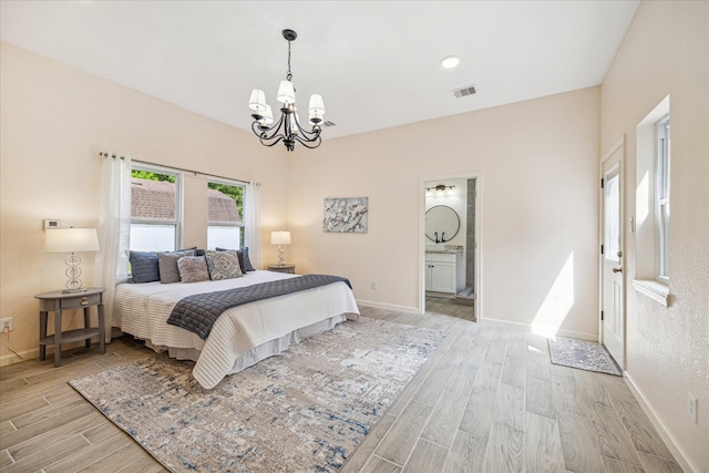 33410 Cripple Creek Dr, Pinehurst, TX 77362 - bedroom with a chandelier, light wood-style floors, and ensuite bathroom