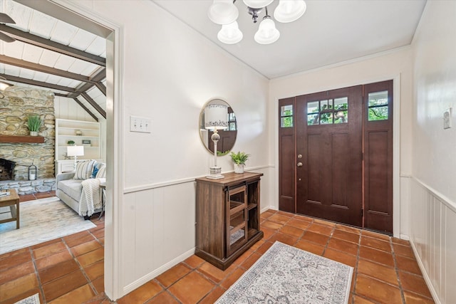 33410 Cripple Creek Dr, Pinehurst, TX 77362 - tiled entryway with a chandelier, a wainscoted wall, a decorative wall, and ornamental molding