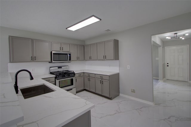 11623 Silent Elm St, Houston, TX 77044 - kitchen with gray cabinets, appliances with stainless steel finishes, light marble finish floors, and light stone counters