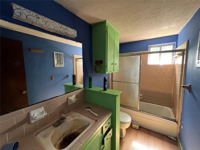 3709 Kettering Ave, Bay City, TX 77414 - full bathroom with vanity, wood finished floors, bath / shower combo with glass door, and a textured ceiling