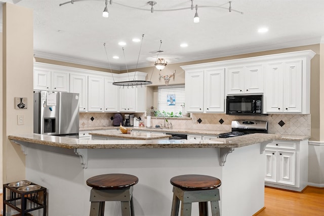 24418 Okehampton Dr, Tomball, TX 77375 - kitchen featuring black appliances, white cabinets, ornamental molding, and recessed lighting