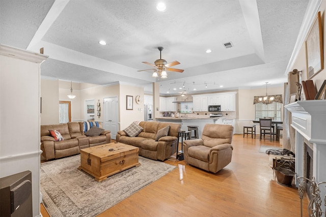 24418 Okehampton Dr, Tomball, TX 77375 - living area with a raised ceiling, a textured ceiling, light wood-type flooring, a ceiling fan, and recessed lighting