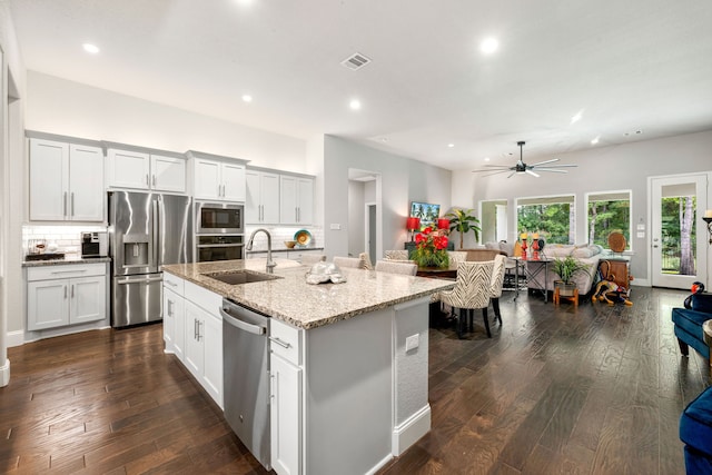 27688 Vivace Dr, Spring, TX 77386 - kitchen featuring stainless steel appliances, open floor plan, recessed lighting, decorative backsplash, and dark wood-type flooring