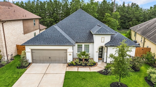 27688 Vivace Dr, Spring, TX 77386 - french country home with a shingled roof, a garage, stucco siding, and driveway