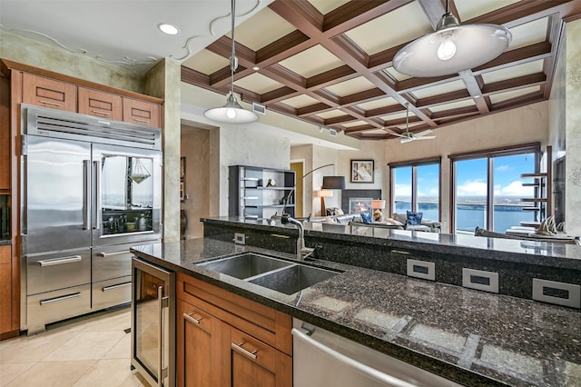 4821 Nasa Pkwy Unit 18W, Seabrook, TX 77586 - kitchen featuring stainless steel appliances, beverage cooler, open floor plan, brown cabinets, and beamed ceiling