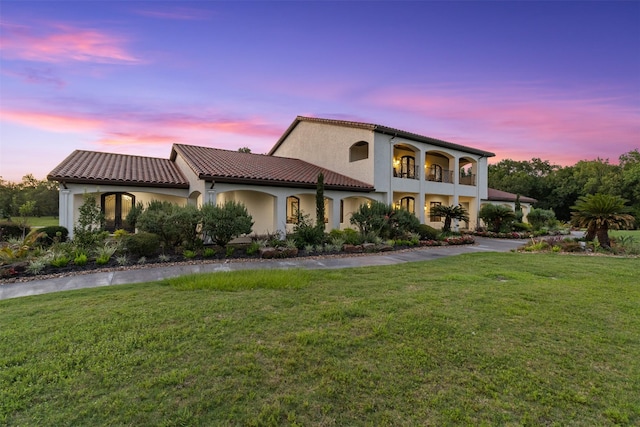 19216 Fm 442nd Rd, Needville, TX 77461 - mediterranean / spanish house with a front lawn, stucco siding, a balcony, and a tiled roof