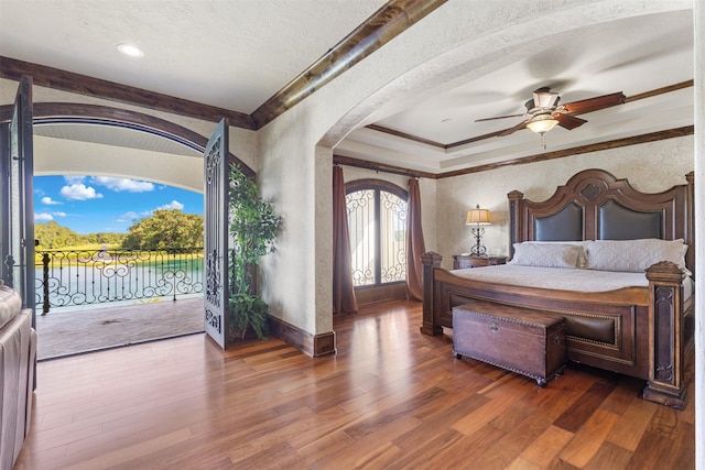 19216 Fm 442nd Rd, Needville, TX 77461 - bedroom featuring ornamental molding, arched walkways, access to outside, wood finished floors, and a textured wall