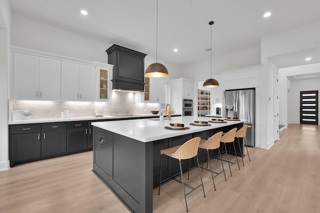 5212 Liberty Cove Dr, Spring, TX 77386 - kitchen with stainless steel appliances, a large island with sink, white cabinets, tasteful backsplash, and recessed lighting