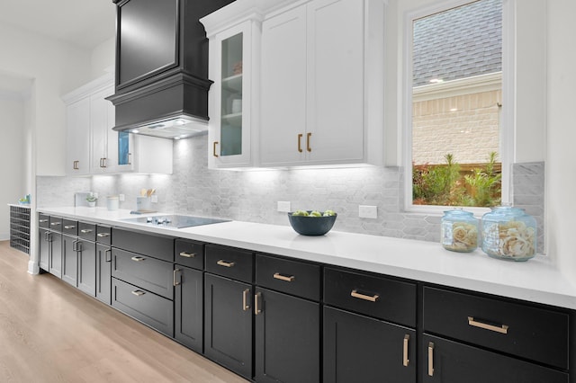 5212 Liberty Cove Dr, Spring, TX 77386 - kitchen featuring white cabinetry, light wood-type flooring, black electric stovetop, light countertops, and backsplash