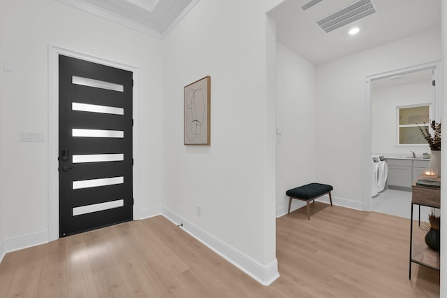 5212 Liberty Cove Dr, Spring, TX 77386 - entryway with washer / dryer, ornamental molding, and light wood-type flooring