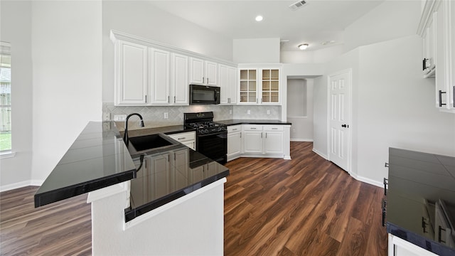 3119 Emory Oak Ln, Pearland, TX 77584 - kitchen with black appliances, a peninsula, white cabinetry, glass insert cabinets, and tasteful backsplash