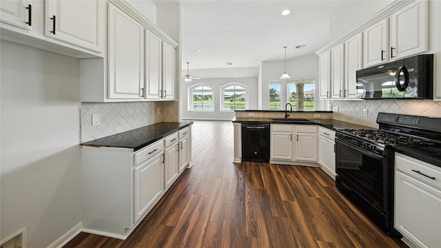 3119 Emory Oak Ln, Pearland, TX 77584 - kitchen with black appliances, dark countertops, dark wood finished floors, a peninsula, and white cabinets
