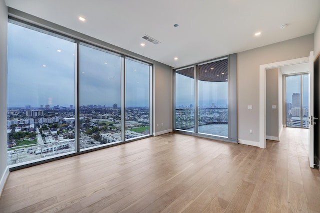 1711 Allen Pkwy Unit 2203, Houston, TX 77019 - spare room with floor to ceiling windows, a city view, hardwood / wood-style floors, and a smoke detector