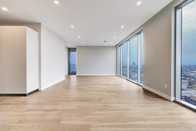 1711 Allen Pkwy Unit 2203, Houston, TX 77019 - unfurnished room with a wall of windows, light wood finished floors, and recessed lighting