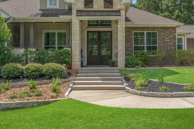 115 Dedication Trl, Huntsville, TX 77340 - doorway to property with french doors, a shingled roof, a lawn, and stone siding