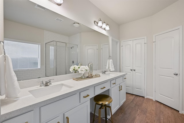 1838 Alyssa Way, Alvin, TX 77511 - bathroom with double vanity, a shower stall, wood finished floors, and a closet