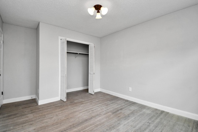 1030 San Felipe Rd, Sealy, TX 77474 - unfurnished bedroom with wood finished floors, a closet, and a textured ceiling
