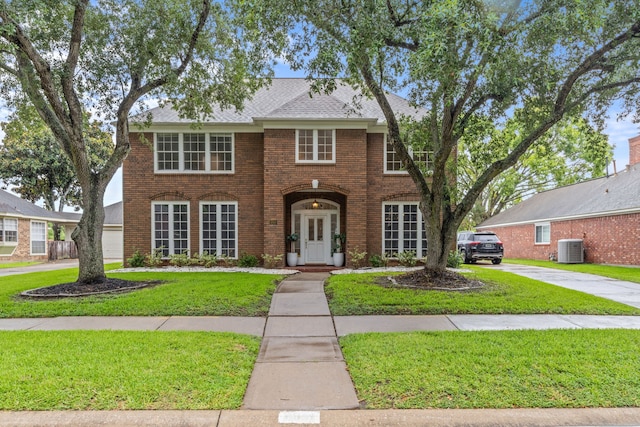 4814 Kirkwall Dr, Sugar Land, TX 77479 - colonial home featuring brick siding, a front lawn, roof with shingles, and concrete driveway