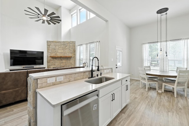 16413 Stonewall St, Conroe, TX 77303 - kitchen featuring dishwasher, open floor plan, white cabinets, light countertops, and a kitchen island with sink