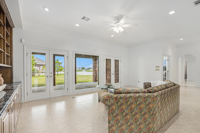 4606 Silhouette Dr, Katy, TX 77493 - living room featuring french doors, arched walkways, light tile patterned flooring, plenty of natural light, and recessed lighting