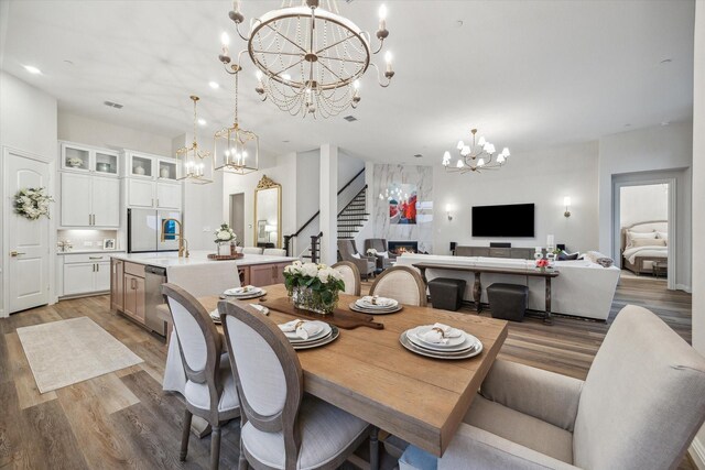 631 Rita Blanca Dr, Webster, TX 77598 - dining space featuring a chandelier, stairway, and light wood-type flooring
