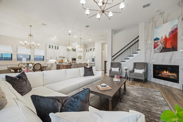 631 Rita Blanca Dr, Webster, TX 77598 - living room with a chandelier, wood finished floors, a high end fireplace, stairs, and recessed lighting