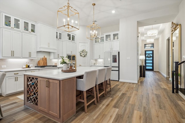 631 Rita Blanca Dr, Webster, TX 77598 - kitchen with white fridge, a chandelier, gas cooktop, a kitchen island, and recessed lighting