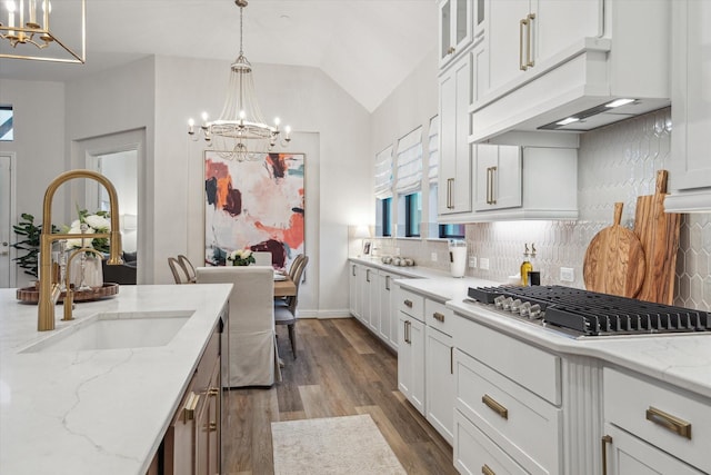 631 Rita Blanca Dr, Webster, TX 77598 - kitchen with a chandelier, stainless steel gas cooktop, backsplash, dark wood-style floors, and lofted ceiling