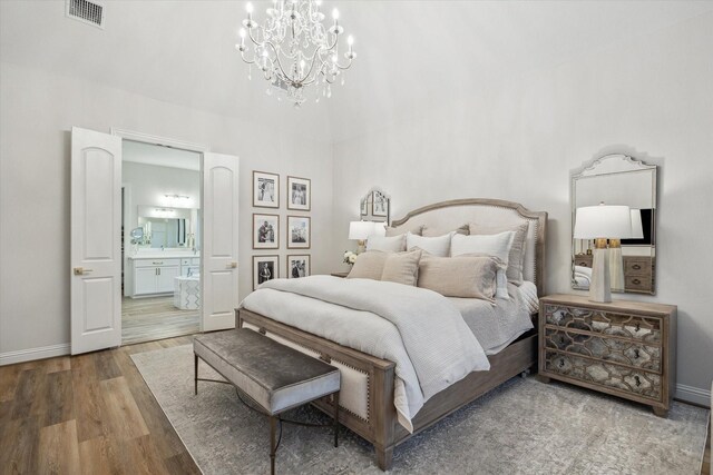 631 Rita Blanca Dr, Webster, TX 77598 - bedroom with a chandelier, wood finished floors, and ensuite bathroom