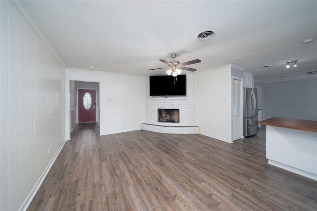 7602 Jackwood St, Houston, TX 77074 - unfurnished living room featuring ceiling fan, dark wood finished floors, crown molding, and a brick fireplace
