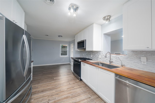 7602 Jackwood St, Houston, TX 77074 - kitchen featuring appliances with stainless steel finishes, wood counters, decorative backsplash, and crown molding