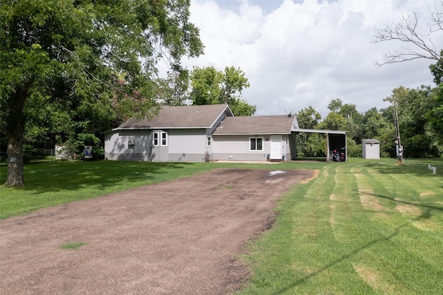 703 Pecan Valley Dr, Wharton, TX 77488 - rear view of house with dirt driveway, a yard, a carport, and a shingled roof