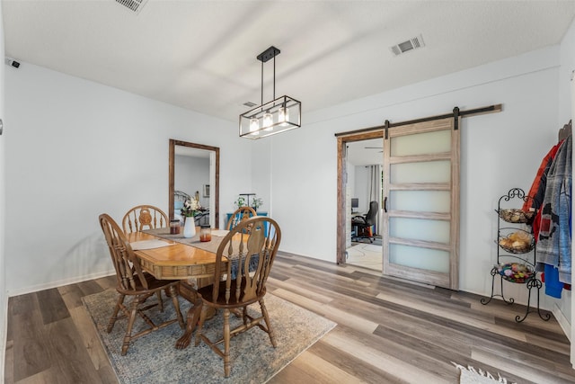 703 Pecan Valley Dr, Wharton, TX 77488 - dining space with a barn door, wood finished floors, and a desk